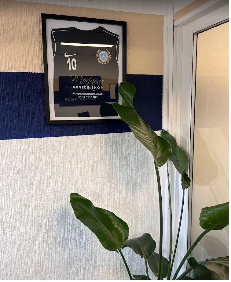 Framed local football shirt on the wall of the First Financial office
